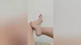 أظهرت الخجولة مع باديكير حمراء ساقيتها المثيرة على الكاميرا